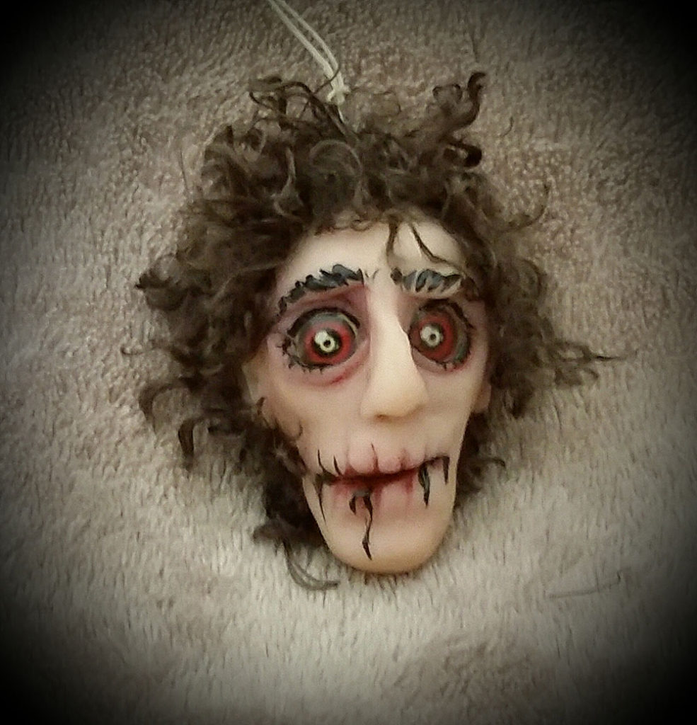 Scary clay formed head with red eyes and brown hair by Tina Parsons